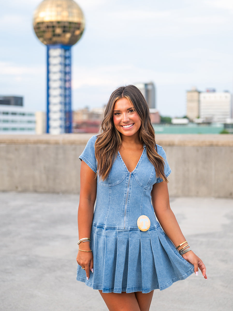 Woman wearing denim mini dress with pleated full skirt