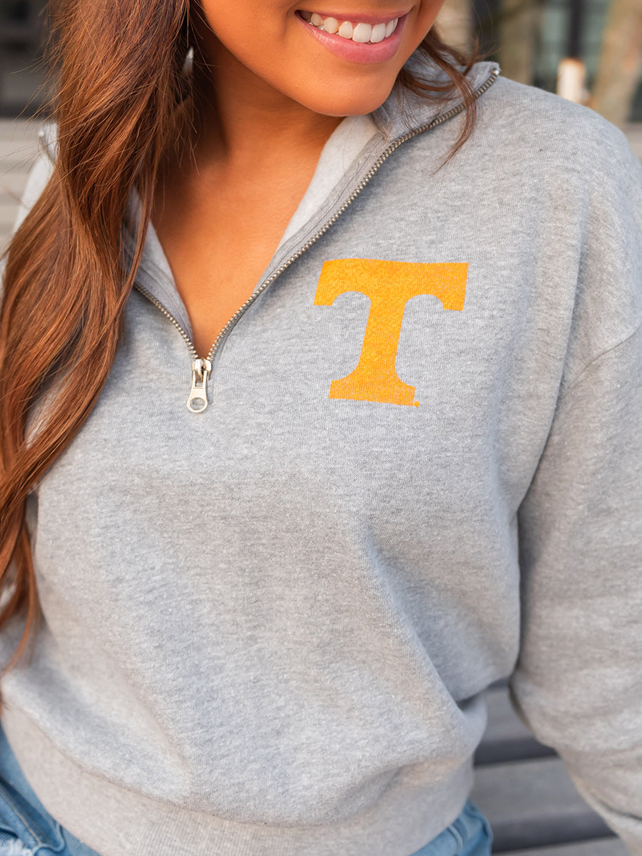 close up of grey quarter zip with orange power t