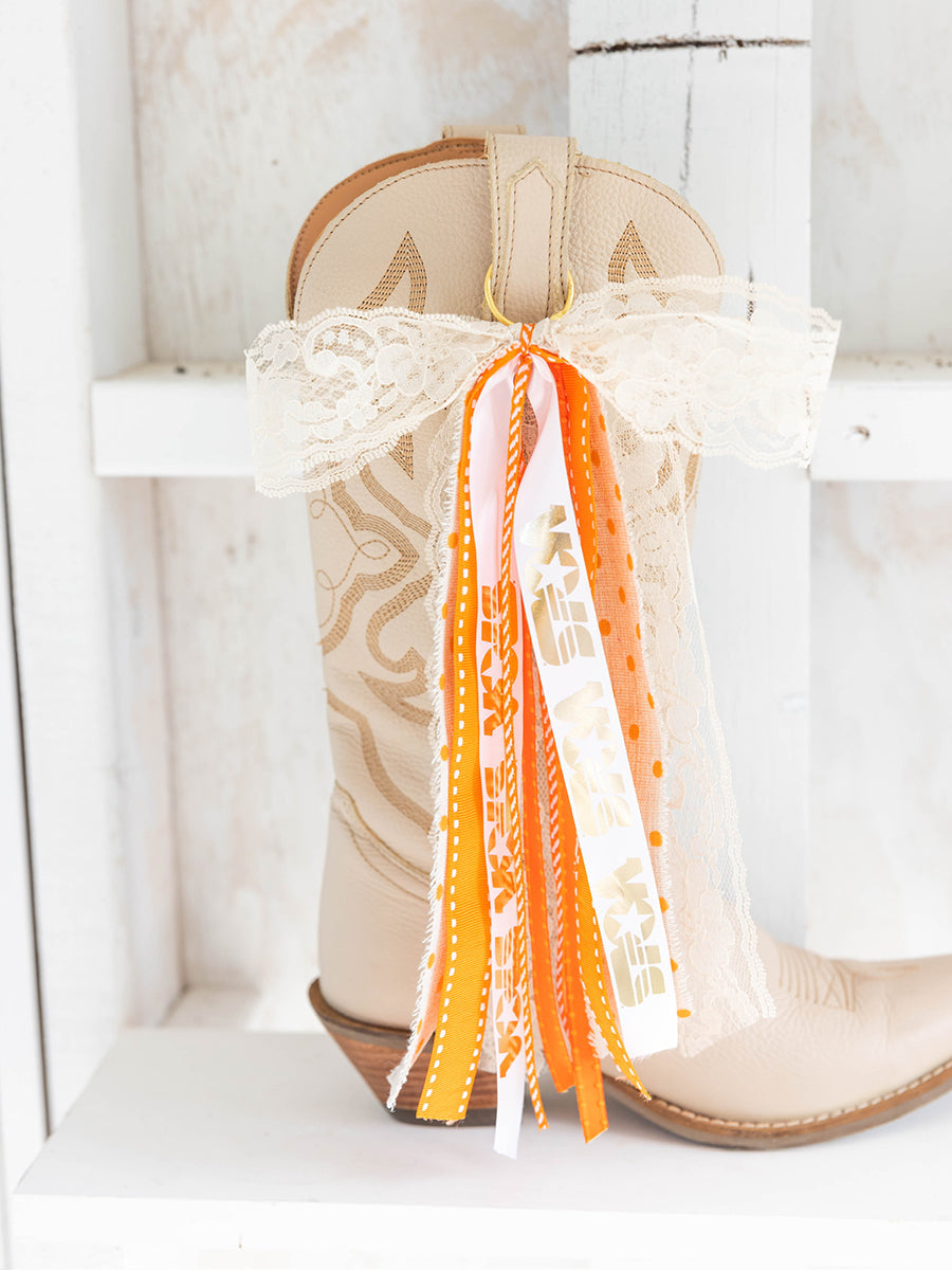 Decorative white and orange bows on boots