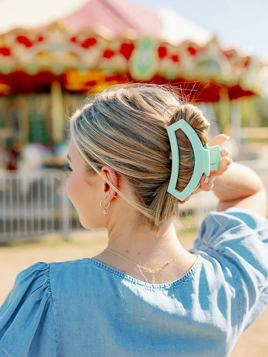 large mint green hair clip in woman's hair