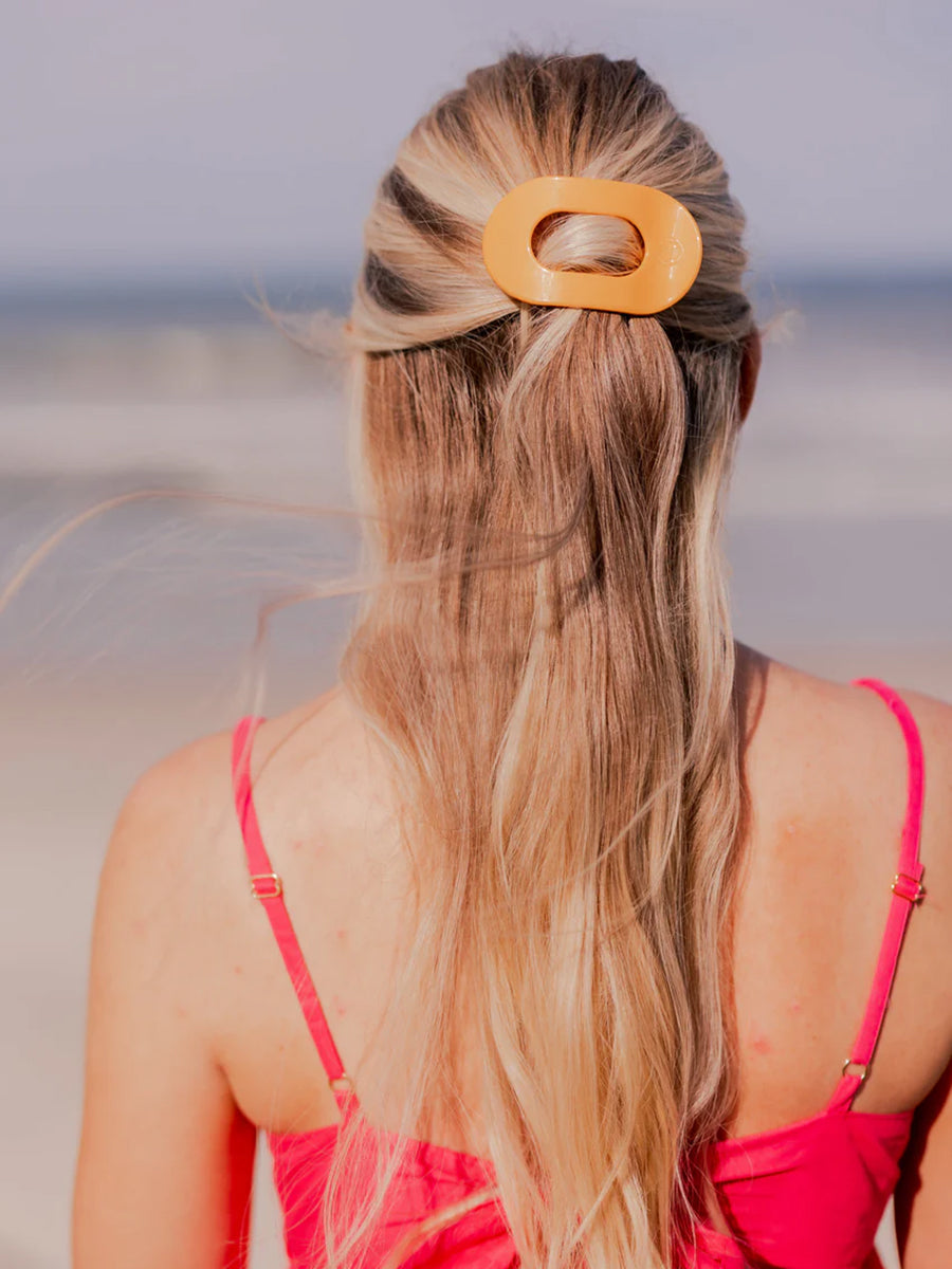 orange hair clip in woman's hair