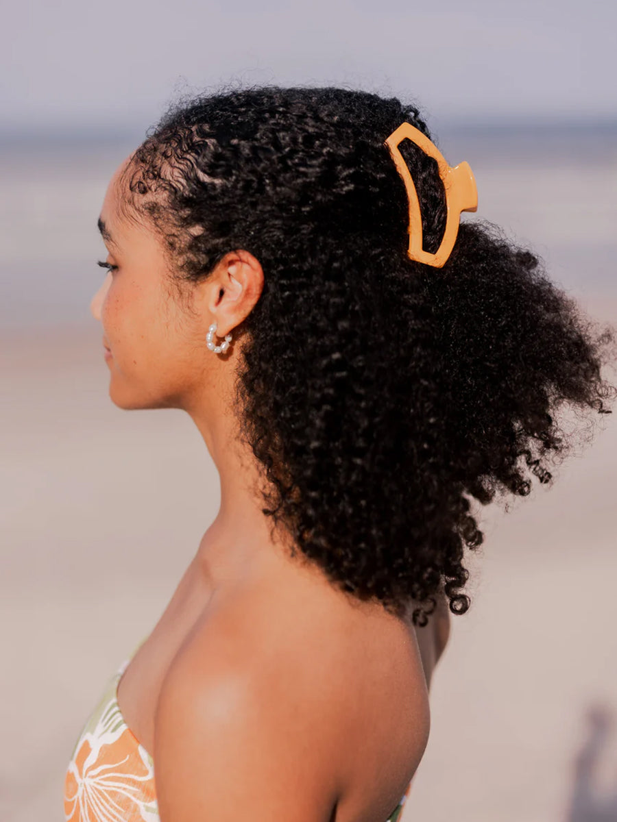 orange hair clip in woman's hair