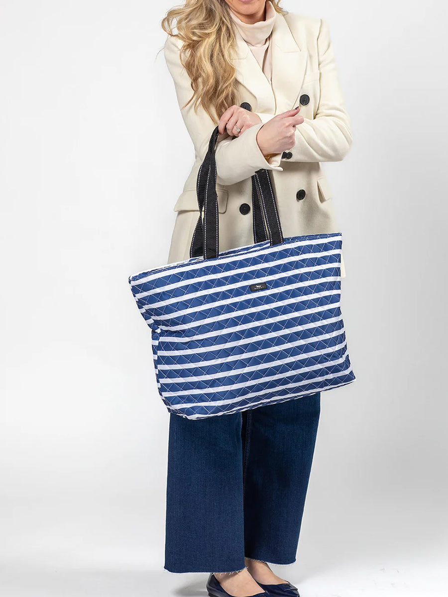 Woman holding quilted travel bag