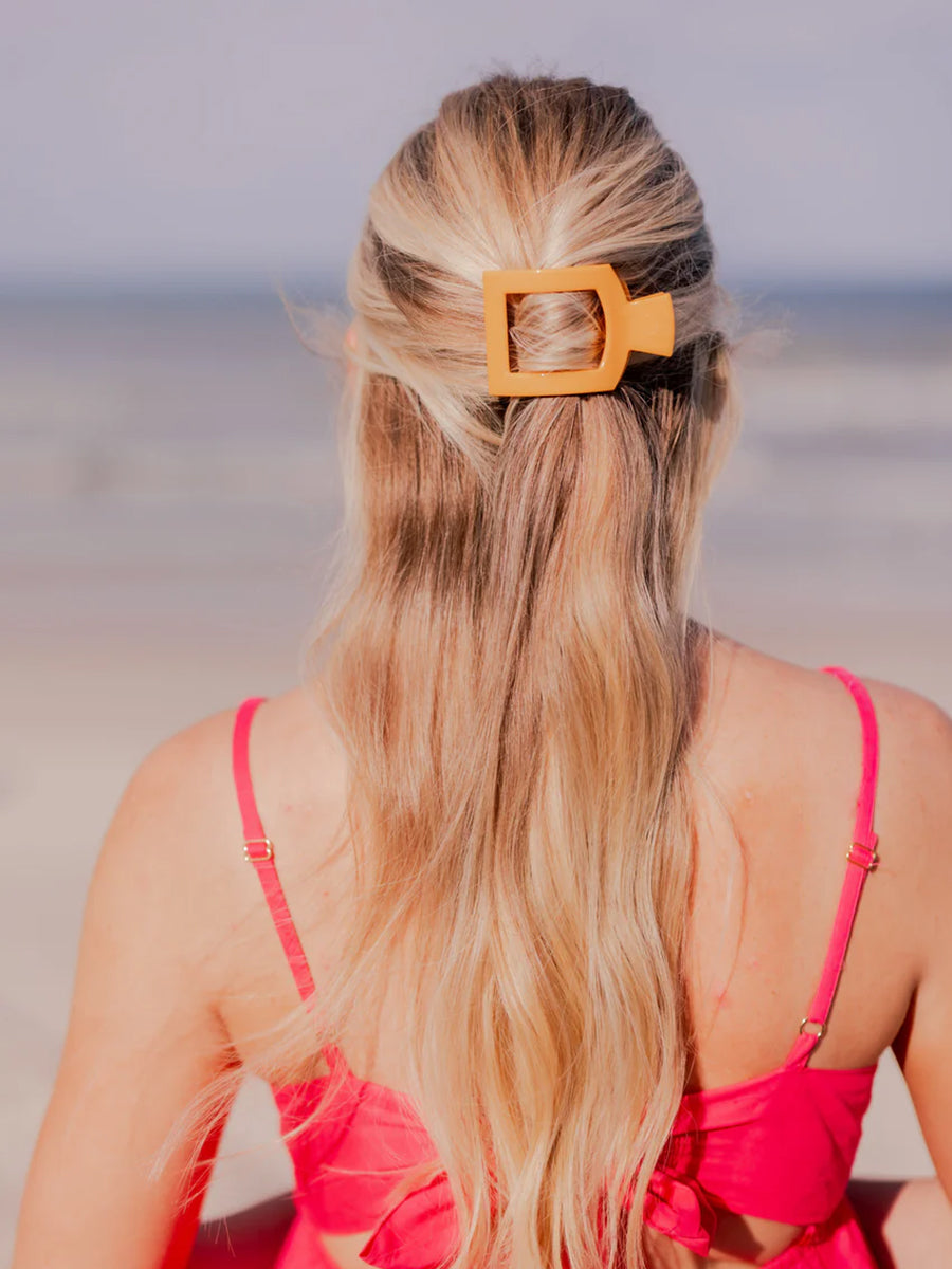 square orange hair clip in woman's hair