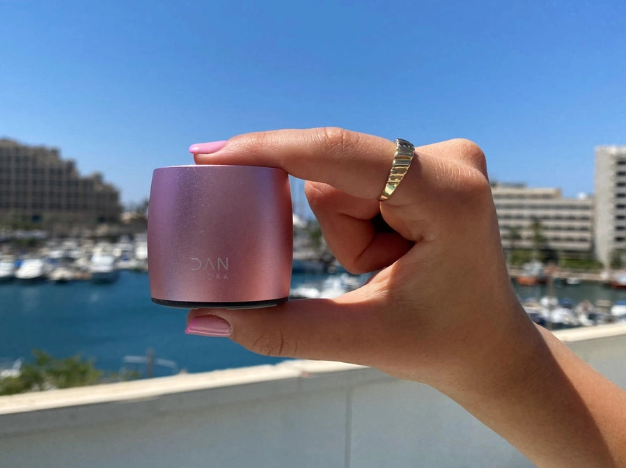 Hand Holding a Small Rose-Colored Speaker