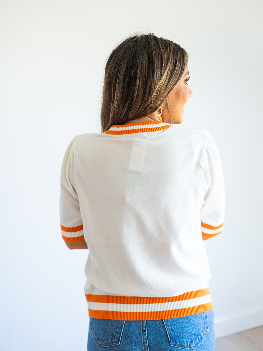 Back of cream and orange sweater