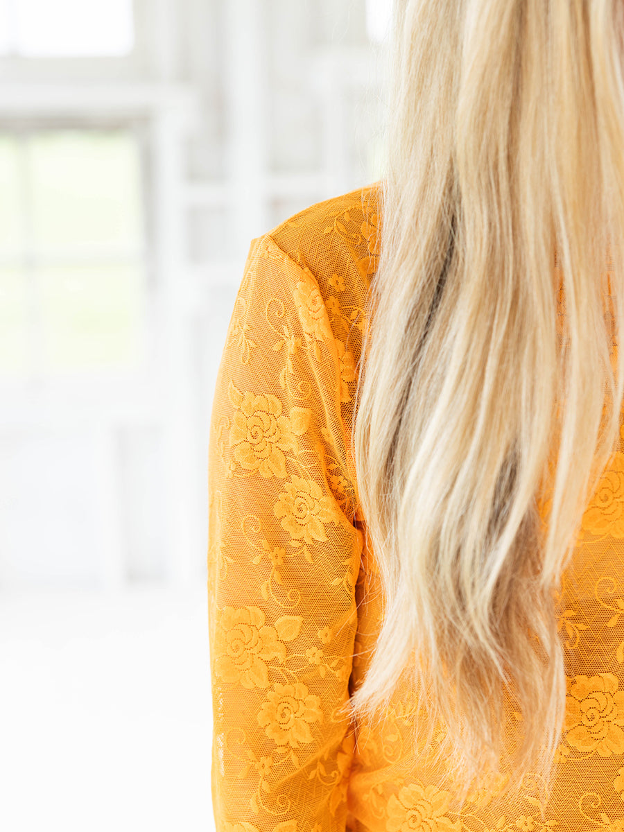 Closeup of the orange floral mesh top