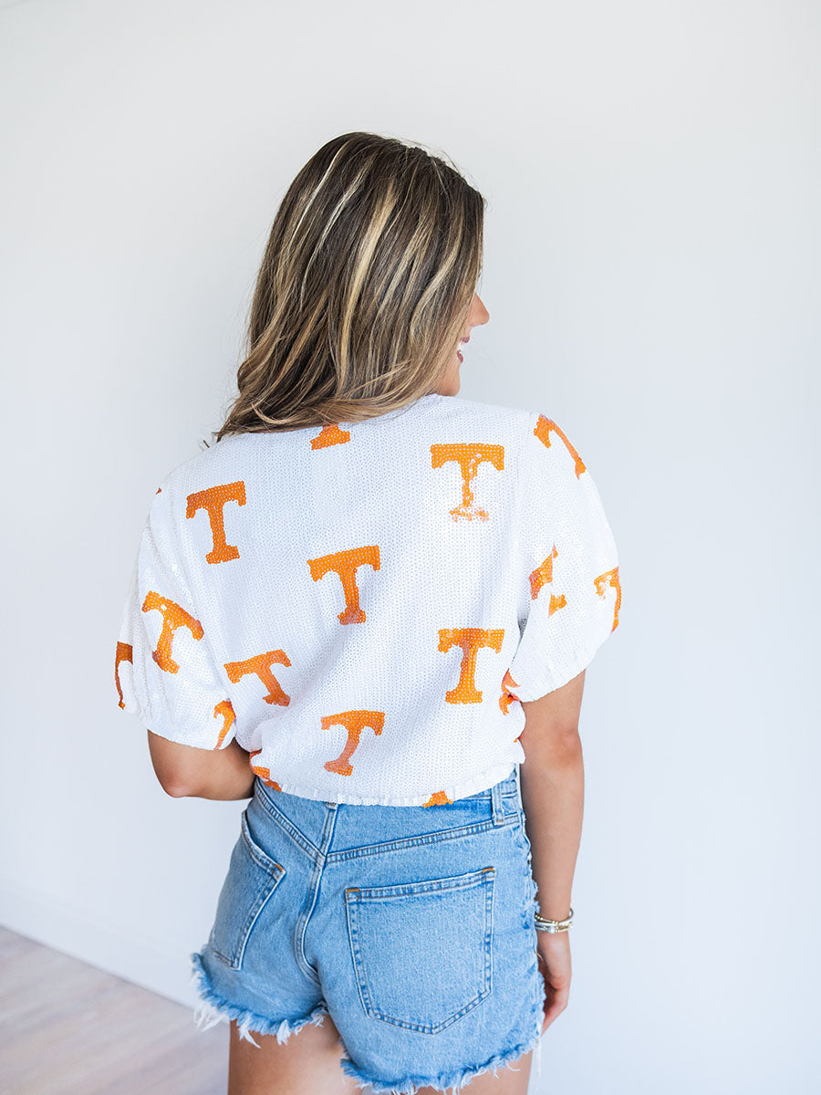 Back of white sequin top with orange "Power T's"